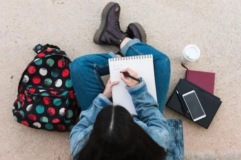 Top view of a college student while she writes in her notebook 스톡 사진