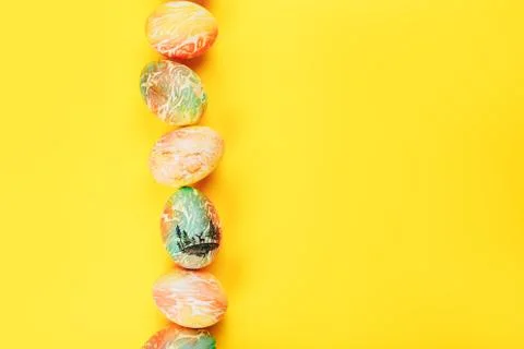 Top view of color easter eggs differen patterns. Line of eggs on yellow Stock Photos