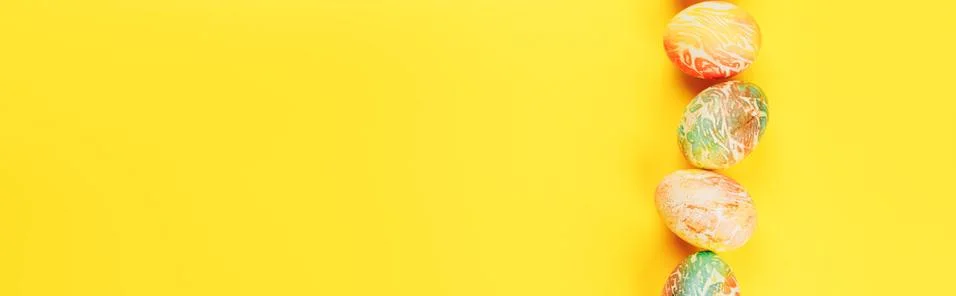Top view of color easter eggs differen patterns. Line of eggs on yellow Stock Photos