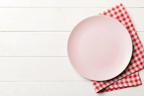 Top view on colored background empty round pink plate on tablecloth for food. Stock Photos