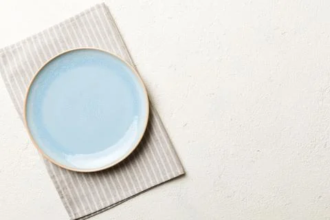 Top view on colored background empty round blue plate on tablecloth for food. Stock Photos