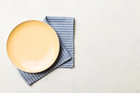 Top view on colored background empty round yellow plate on tablecloth for foo Stock Photos