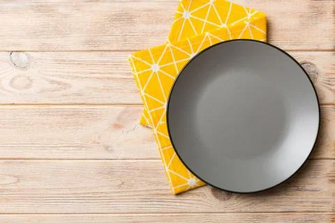Top view on colored background empty round gray plate on tablecloth for food. Stock Photos