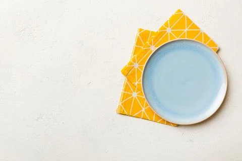 Top view on colored background empty round blue plate on tablecloth for foo.. Stock Photos