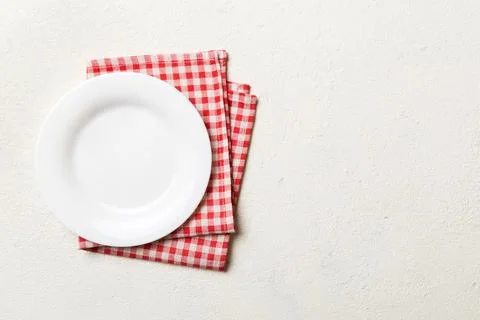 Top view on colored background empty round white plate on tablecloth for food Stock Photos