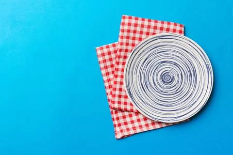 Top view on colored background empty round blue plate on tablecloth for foo.. Stock Photos