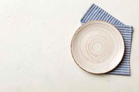 Top view on colored background empty round white plate on tablecloth for food Stock Photos