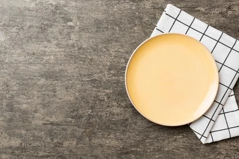 Top view on colored background empty round yellow plate on tablecloth for f.. Stock Photos
