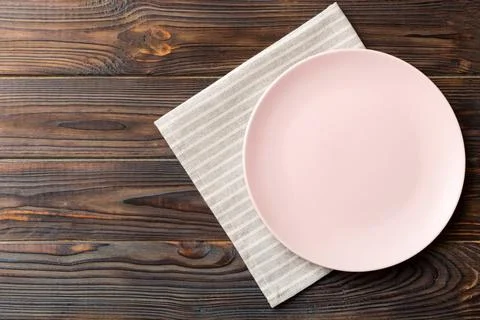 Top view on colored background empty round pink plate on tablecloth for foo.. Stock Photos
