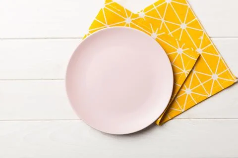 Top view on colored background empty round pink plate on tablecloth for food. Stock Photos