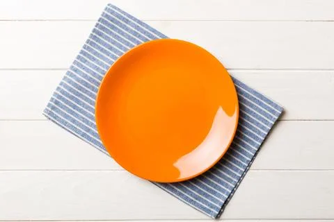 Top view on colored background empty round red plate on tablecloth for food.. Stock Photos