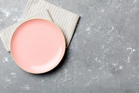 Top view on colored background empty round pink plate on tablecloth for food. Stock Photos
