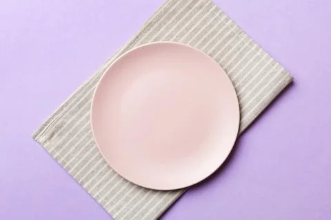 Top view on colored background empty round pink plate on tablecloth for foo.. Stock Photos