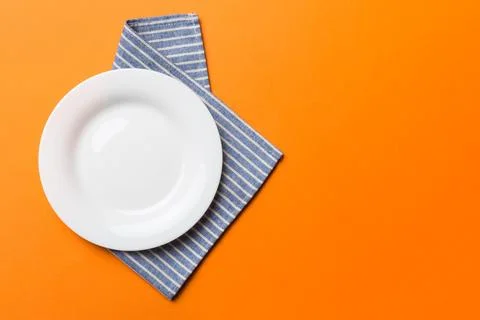 Top view on colored background empty round white plate on tablecloth for fo.. Stock Photos