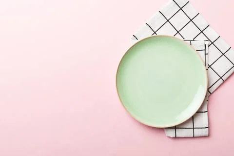 Top view on colored background empty round green plate on tablecloth for fo.. Stock Photos