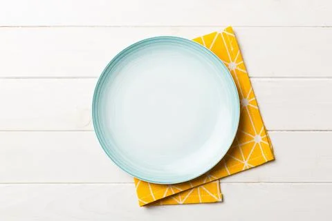 Top view on colored background empty round Blue plate on tablecloth for food. Stock Photos