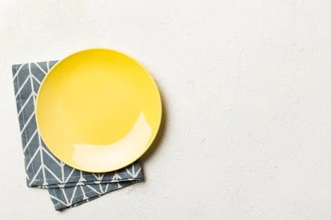 Top view on colored background empty round yellow plate on tablecloth for f.. Stock Photos