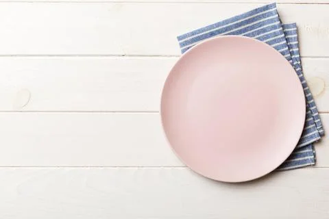 Top view on colored background empty round pink plate on tablecloth for foo.. Stock Photos