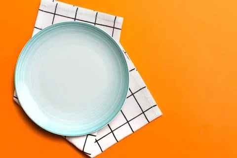 Top view on colored background empty round Blue plate on tablecloth for food. Stock Photos