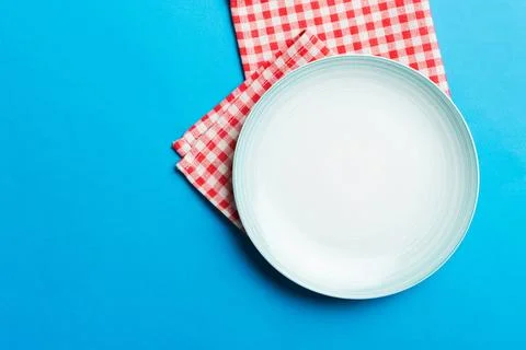 Top view on colored background empty round Blue plate on tablecloth for food. Stock Photos