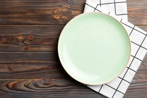 Top view on colored background empty round green plate on tablecloth for food Stock Photos