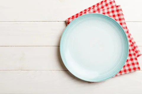 Top view on colored background empty round Blue plate on tablecloth for food. Stock Photos