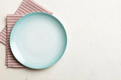 Top view on colored background empty round blue plate on tablecloth for foo.. Stock Photos