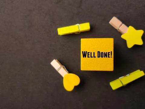 Top view colored block and wooden clips with text WELL DONE Stock Photos