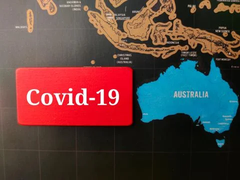 Top view colored board with text Covid 19 on a australia map background. Stock Photos
