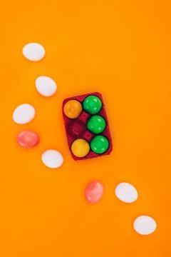 Top view of colored easter eggs in red egg tray isolated on orange Stock Photos