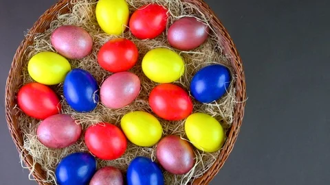Top view Colorful easter eggs lie on a bacon in a basket on a gray background. Stock Footage 125618000
