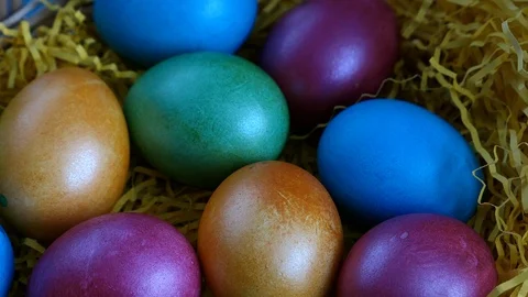 Top View Of Colorful Easter Eggs Lying On Straw In A Basket On A Blue Wooden Bac Stock Footage 126590010
