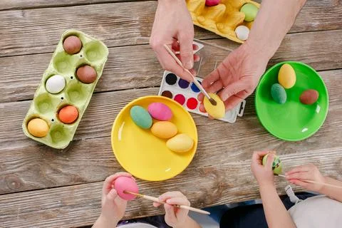 Top view of colorful Easter eggs, paints and brushes on wooden Stock Photos