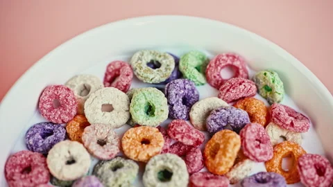 Top View of Colorful Fruit Cereal Loops in Milk on Pink Background Stock Footage 335895011