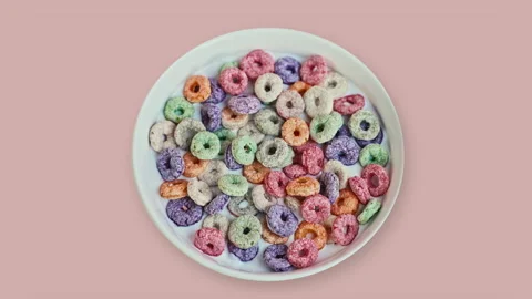 Top View of Colorful Fruit Cereal Loops in Milk on Pink Background Vídeo Stock 335895053