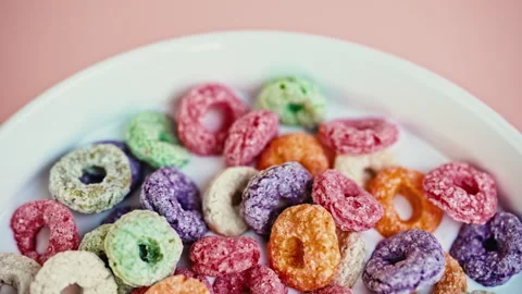 Top View of Colorful Fruit Cereal Loops in Milk on Pink Background Vídeo Stock 344687158