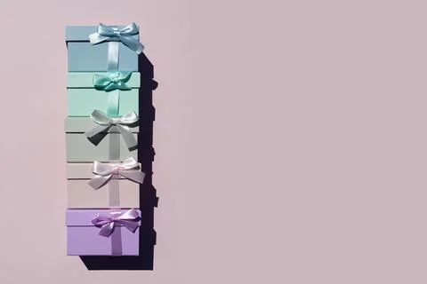 Top view of colorful gift boxes tied with ribbons on pink background. Place for Stock Photos