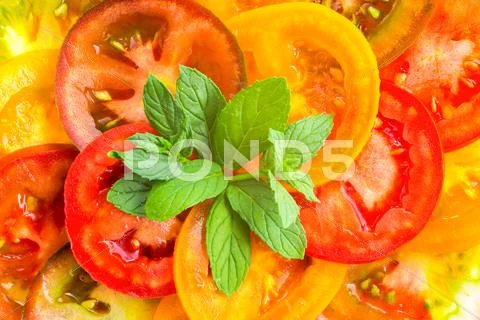 Top View Of Colorful Tomato Slices With Green Twig Mint, Fresh Organic Food