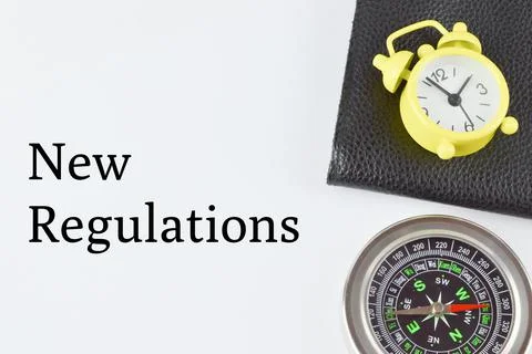 Top view of compass, clock and file over white background with text NEW REGUL Foto stock