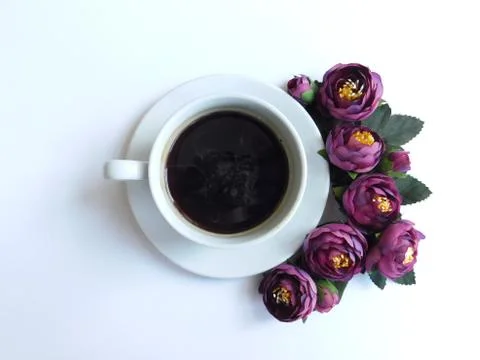 Top view composition. Coffee in white cup with violet peonies, flat lay. Stock Photos