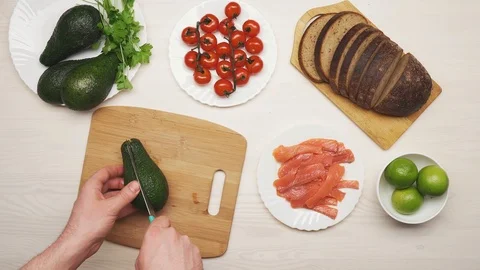 Top view composition of ingredients for sandwiches with avocado, red fish fillet Stock Footage 104654841