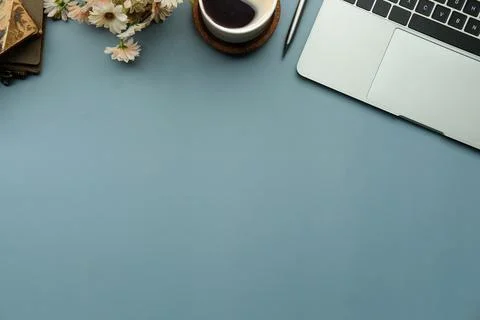 Top view, computer laptop, coffee cup and book on blue background. Stock Photos