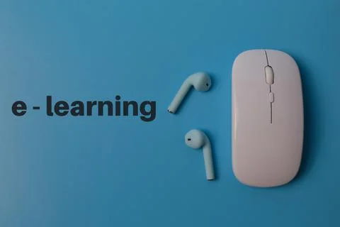 Top view of computer mouse and earbuds on blue background written with E - LE Foto stock