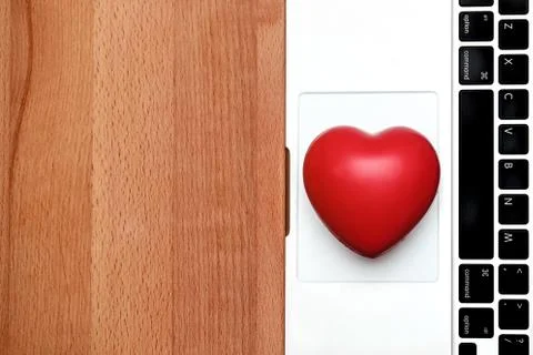Top view computer notebook and small heart with copy space on wooden Stock Photos