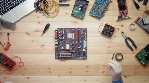 Top view computer technician testing motherboard at wooden desk with tools and Stock Footage 74893268
