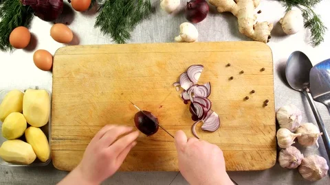 Top view cook cuts a onion into half rings and shreds it on a cutting board Stock Footage 76114272