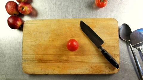 Top view cook cuts tomato into slices on a cutting board Stock Footage 76112880