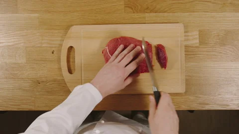 TOP VIEW: Cook cutting the beef on a board Stock Footage 130260155