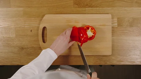 TOP VIEW: Cook cutting red pepper on a board Stock Footage 130260092