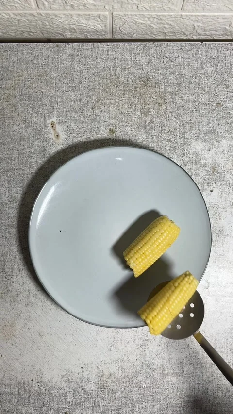 Top view. Cook puts pieces of boiled yellow half an cob of corn Stock Footage 280915918